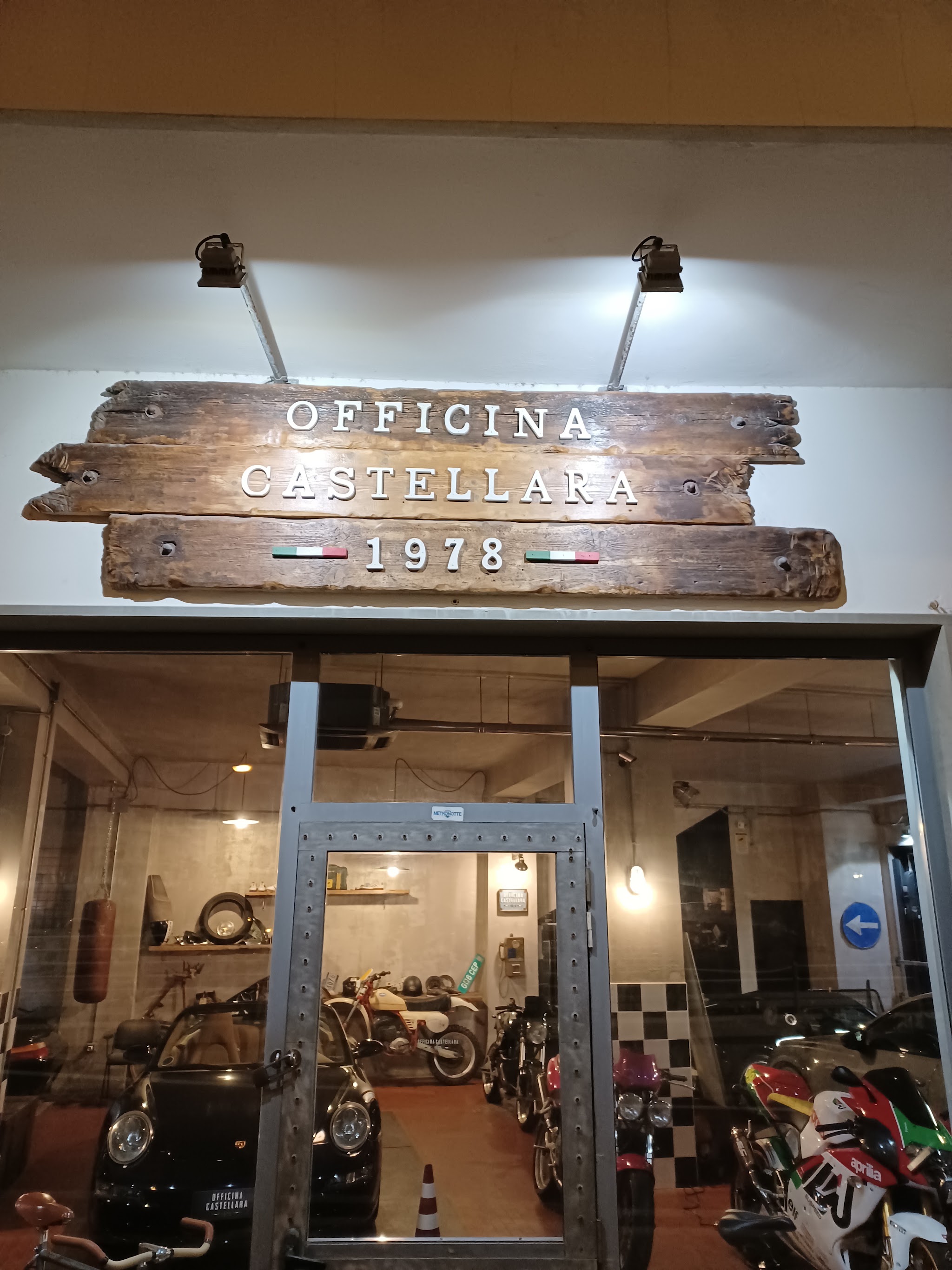 Ingresso di Officina Castellara 1978 con auto e moto in esposizione