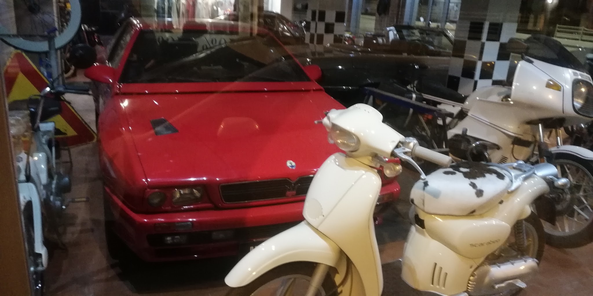 Auto e scooter classici esposti nell’ambiente dell’officina