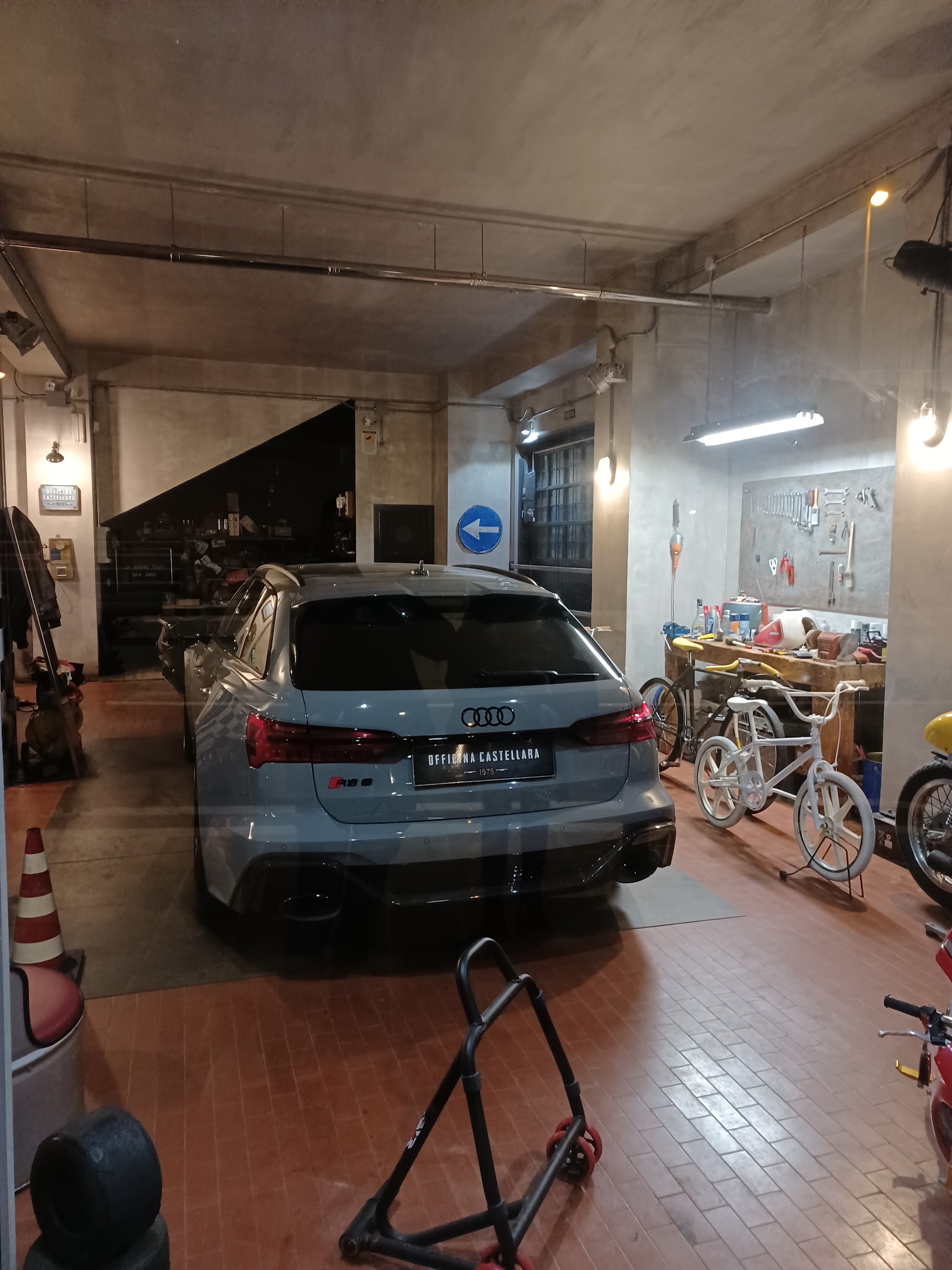 Audi all’interno dell’officina con banco da lavoro e biciclette