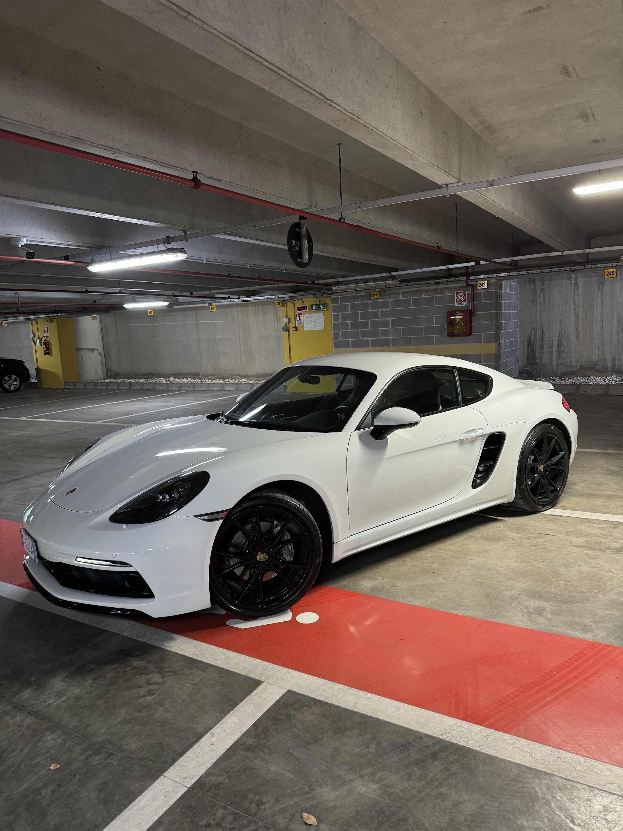 Porsche bianca fotografata in un parcheggio coperto